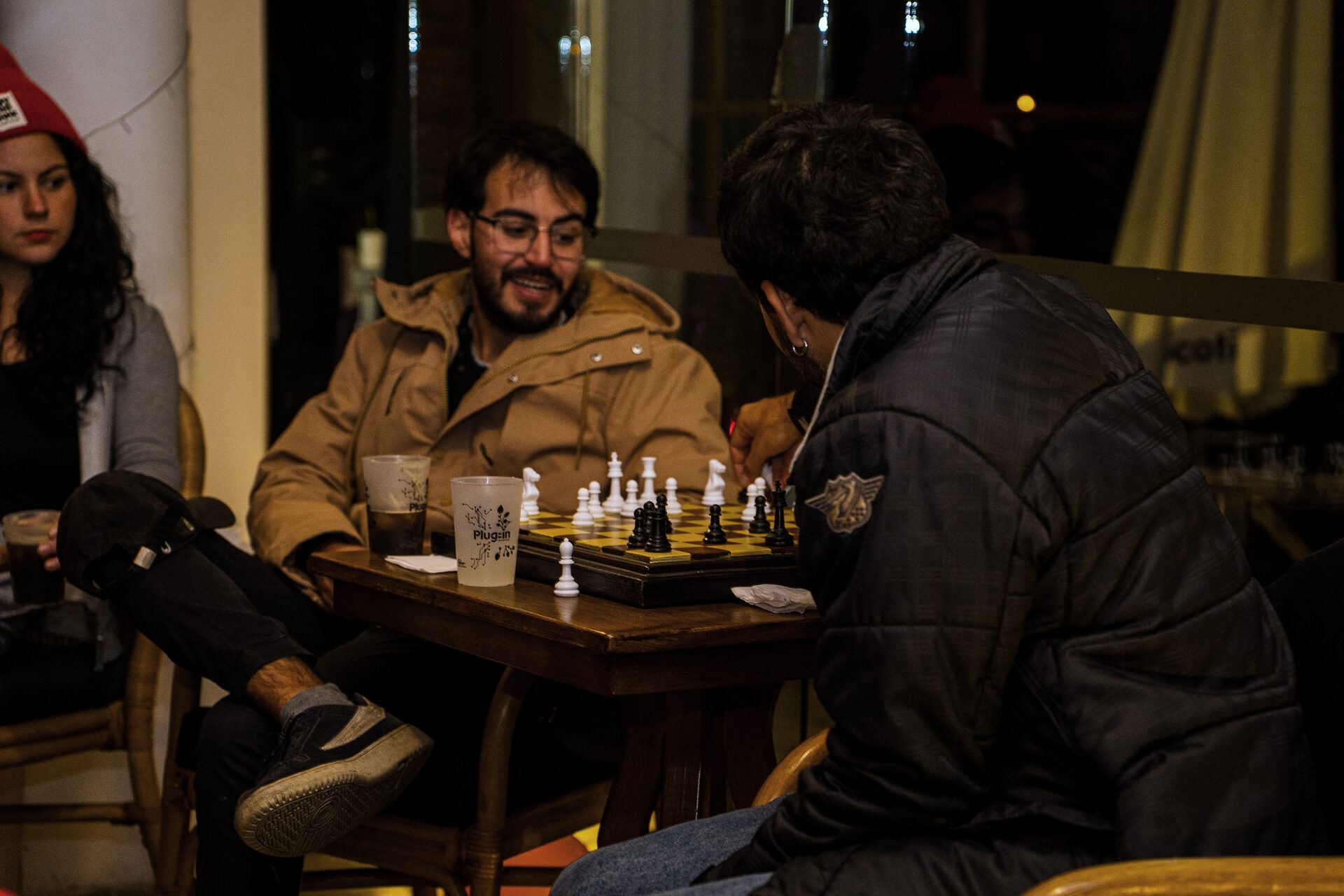 Two guests playing chess at a wooden table during the gathering.