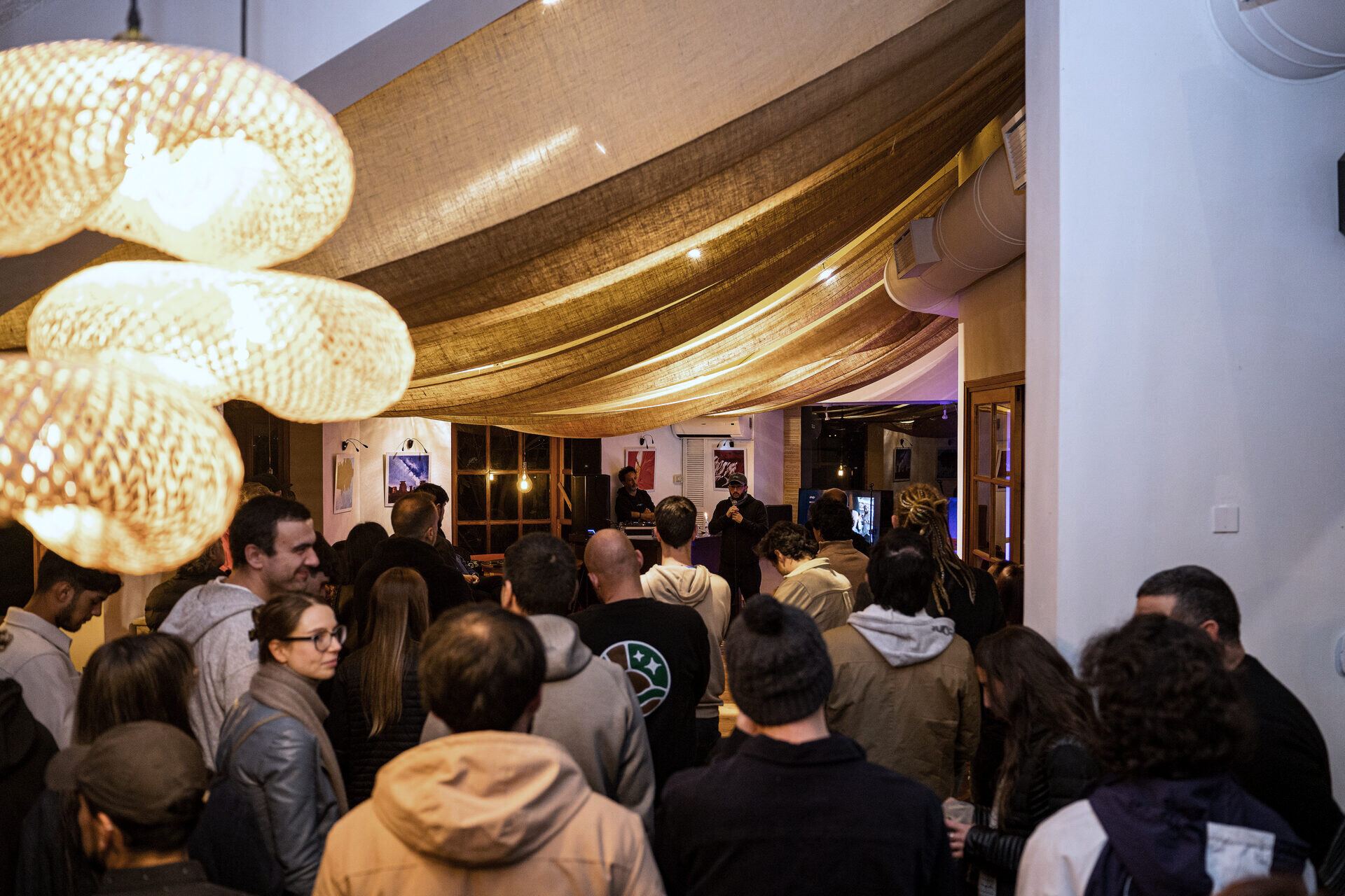 Guests gathered under the wicker lamps during a gathering.